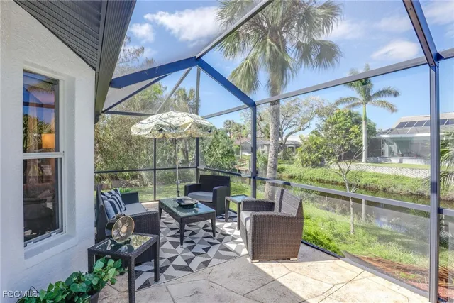 a patio with glass top table and chairs