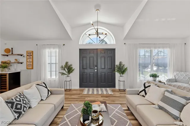 a living room with furniture a potted plant and a large window