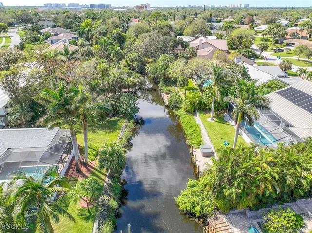 an aerial view of a house with a yard and lake view