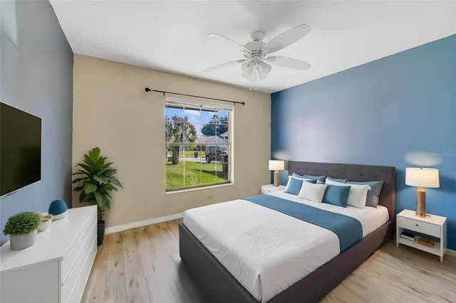 a bedroom with a large bed and a potted plant