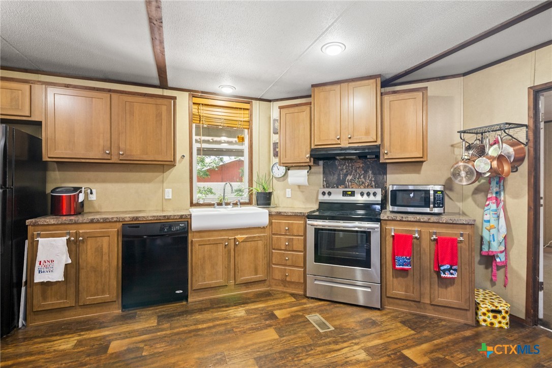 3308 Catalpa Street Victoria, TX 77901 - Photo 11 of 22 a kitchen with stainless steel appliances granite countertop a stove a sink and a refrigerator