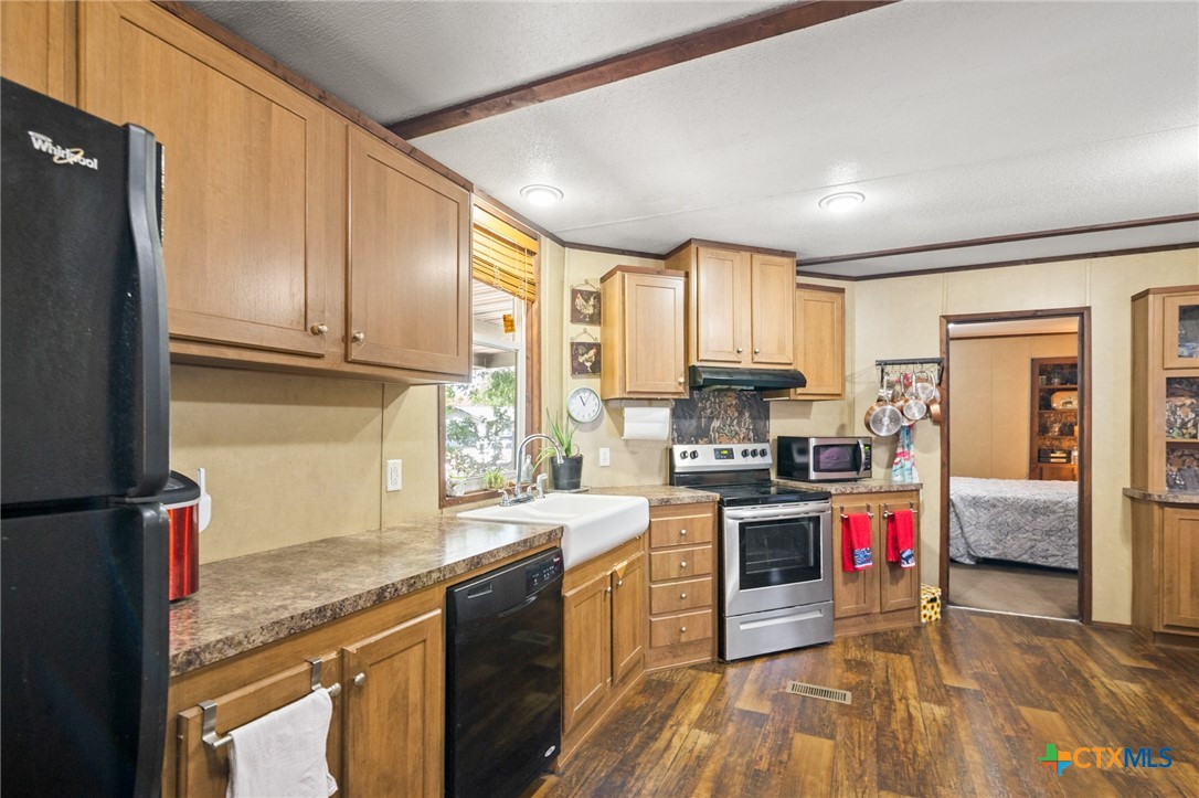 3308 Catalpa Street Victoria, TX 77901 - Photo 12 of 22 a kitchen with stainless steel appliances granite countertop a stove top oven a sink dishwasher a dining table and chairs with wooden floor