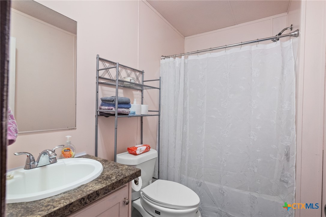 3308 Catalpa Street Victoria, TX 77901 - Photo 17 of 22 a bathroom with a granite countertop sink toilet and shower