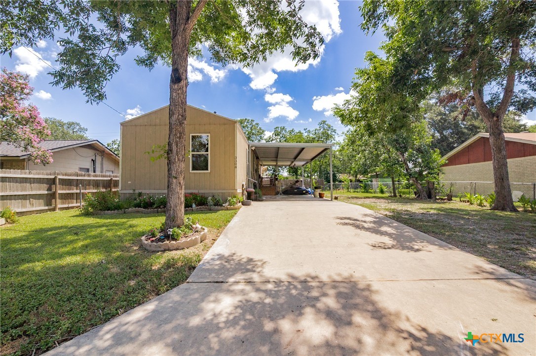 3308 Catalpa Street Victoria, TX 77901 - Photo 2 of 22 a view of a white house next to a yard with big trees