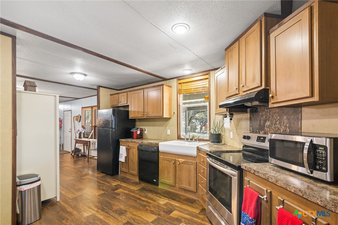 3308 Catalpa Street Victoria, TX 77901 - Photo 10 of 22 a kitchen with stainless steel appliances granite countertop a refrigerator a stove a sink and a microwave