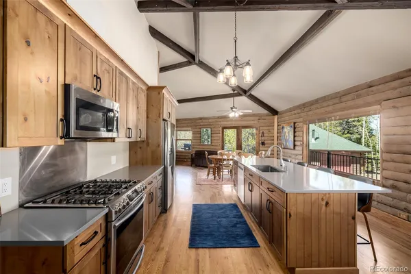a kitchen with stainless steel appliances a stove a sink and a refrigerator