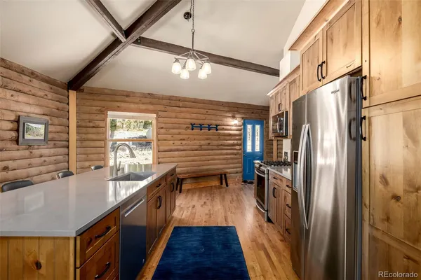 a kitchen with stainless steel appliances granite countertop a sink a refrigerator and a stove