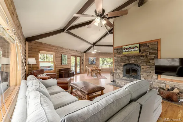 a living room with furniture large window and fireplace