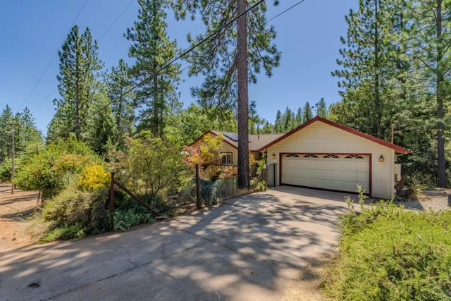 a view of a house with a large tree and a yard