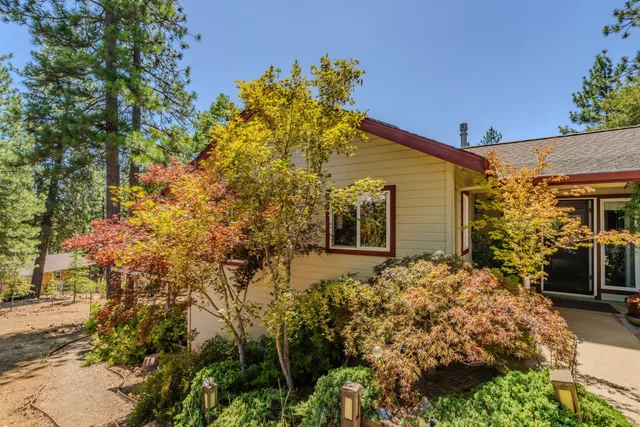 a front view of a house with a tree