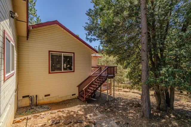 a view of a house with a wooden deck and a yard