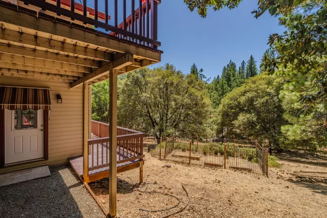 an aerial view of residential house with outdoor space and trees all around
