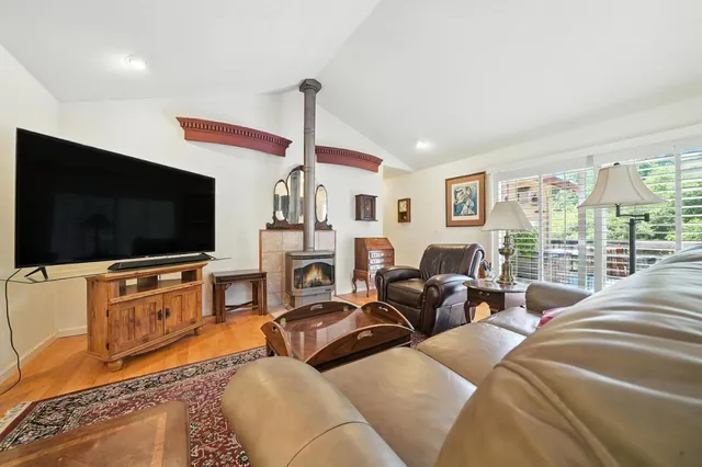 a living room with furniture a flat screen tv and a floor to ceiling window