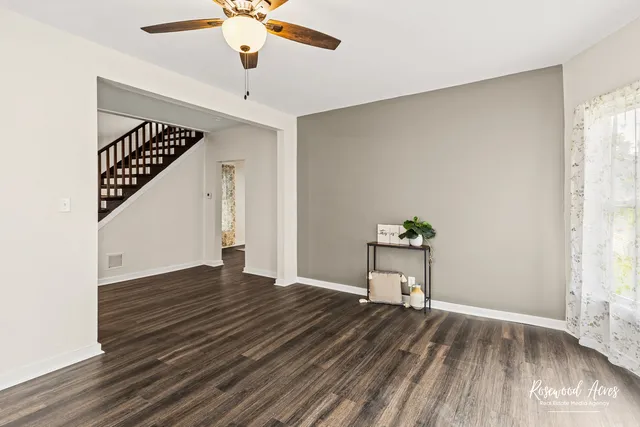 a view of a livingroom with wooden floor and a ceiling fan