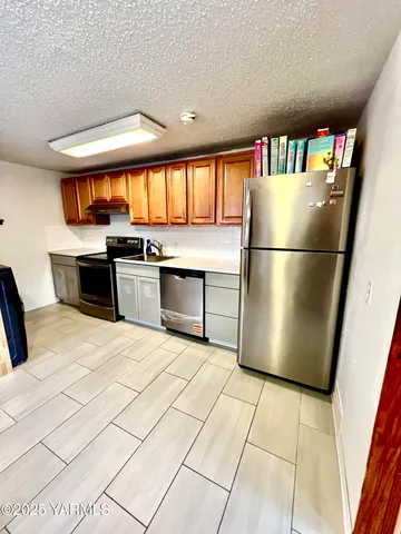 a kitchen with stainless steel appliances granite countertop a refrigerator sink and stove
