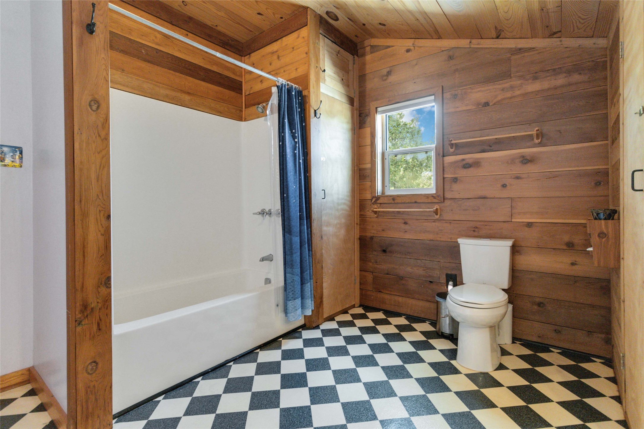 180 Ironstone Road Smithville, TX 78957 - Photo 23 of 37 Full bath with tile patterned floors, a vaulted wooden ceiling, shower / bath combination with curtain, and wooden walls