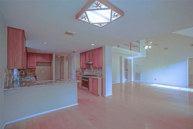 a kitchen with stainless steel appliances granite countertop a stove a sink and a microwave