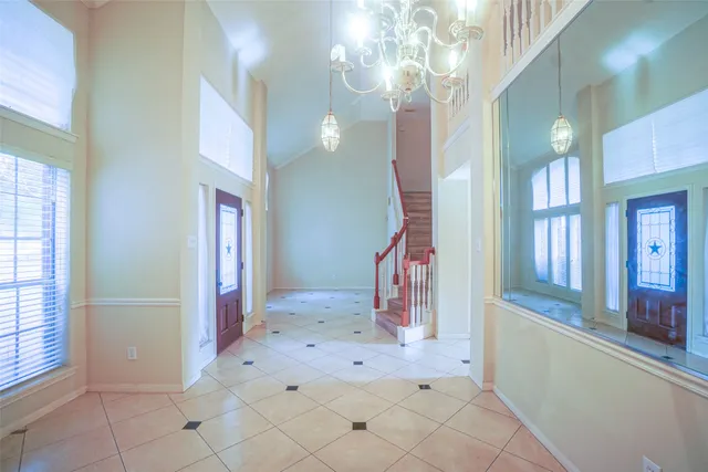 an empty room with wooden floor fireplace and windows