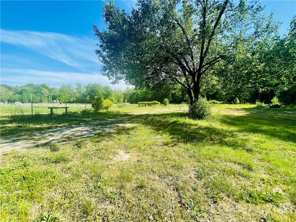 5216 King Wilkinson Road Denver, NC 28037 - Photo 8 of 13 a view of a grassy field with trees