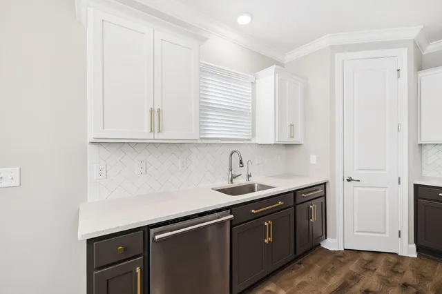 a kitchen with stainless steel appliances granite countertop white cabinets and window