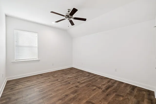 an empty room with a window and a fan
