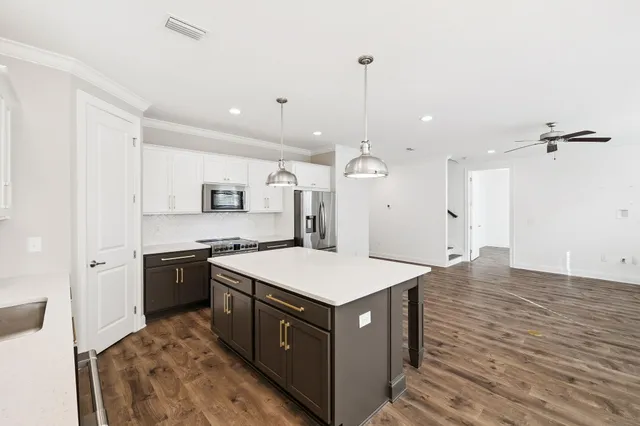 a large kitchen with a stove a sink dishwasher and a refrigerator