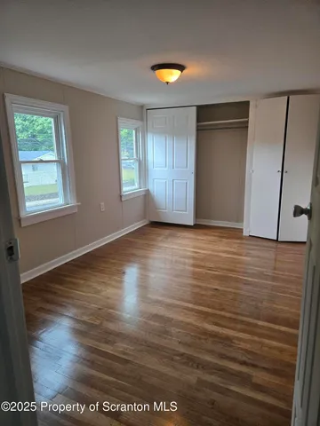 a view of a room with wooden floor