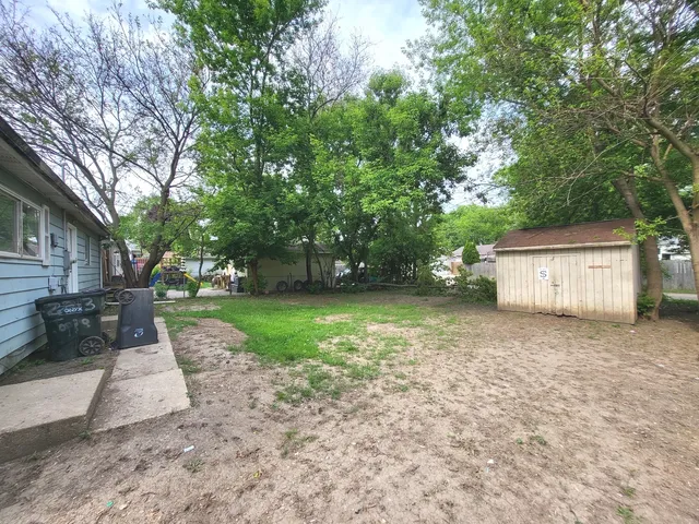 a view of a house with backyard and trees