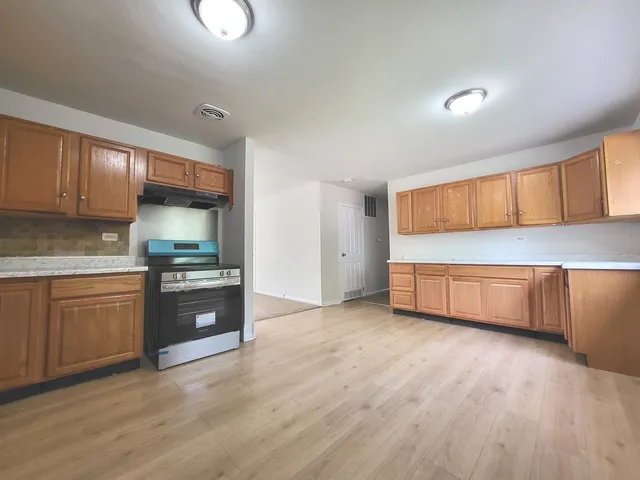 a kitchen with stainless steel appliances granite countertop a stove a sink and a refrigerator