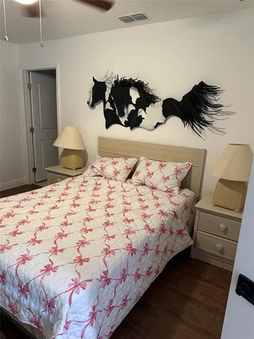 a bedroom with a bed and a lamp on dresser