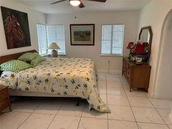 a bedroom with a bed a dresser and painting