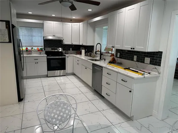 a kitchen with stainless steel appliances kitchen island granite countertop a sink and cabinets
