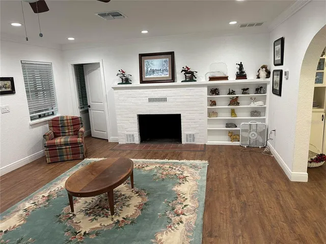 a living room with furniture a fireplace and wooden floor