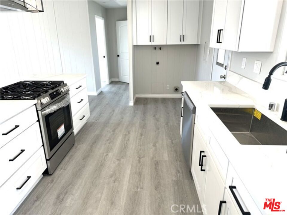 9391 California Avenue, Unit 89 Riverside, CA 92503 - Photo 12 of 16 a kitchen with a sink a stove and cabinets