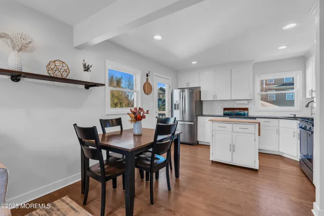 a kitchen with white cabinets and refrigerator