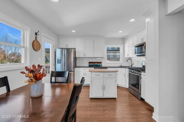 a kitchen with stainless steel appliances granite countertop sink stove refrigerator and cabinets