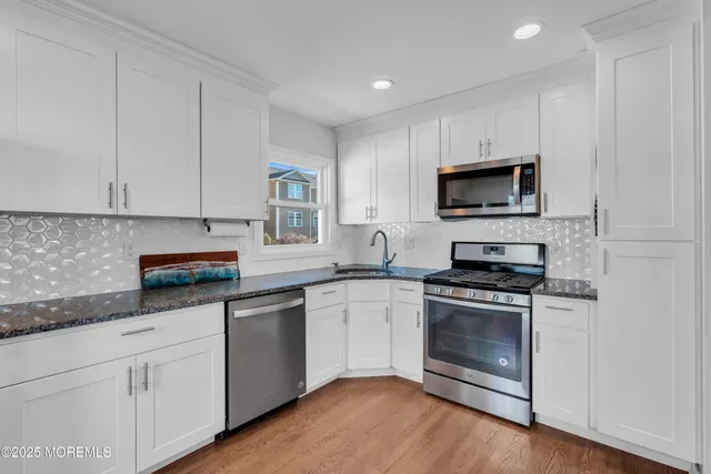 a kitchen with cabinets stainless steel appliances a sink and a microwave