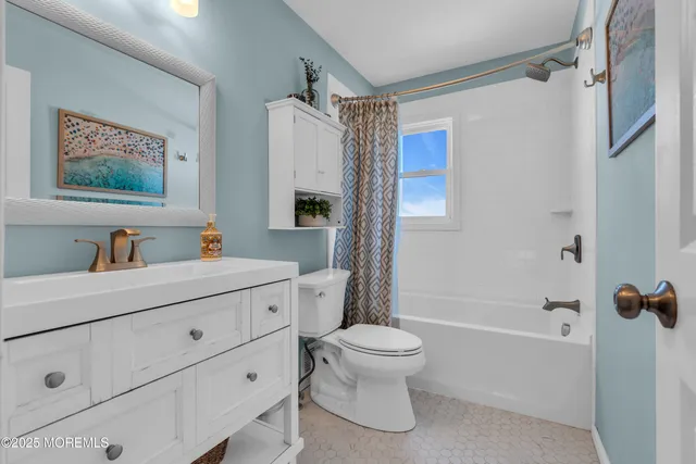 a bathroom with a sink a mirror a toilet and a bathtub