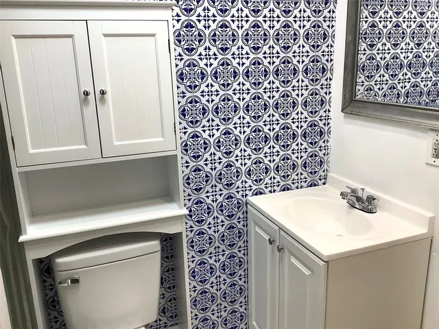 a white toilet sitting next to a shower
