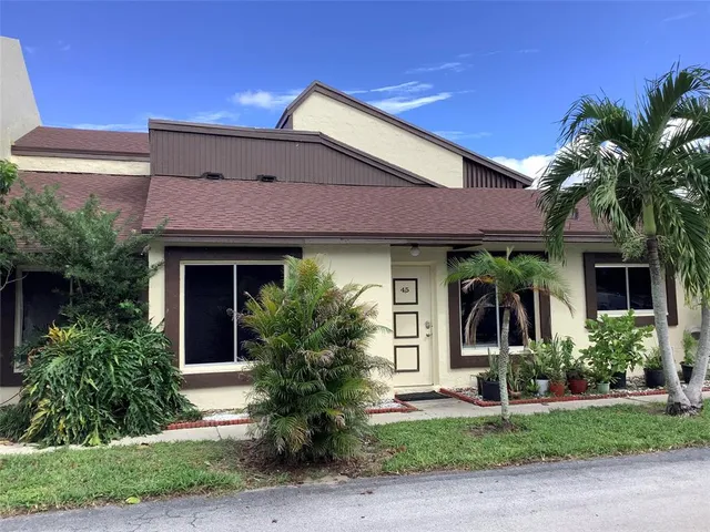 a view of a house with a yard and potted plants
