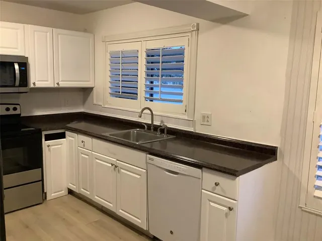 a kitchen with stainless steel appliances a refrigerator stove and microwave