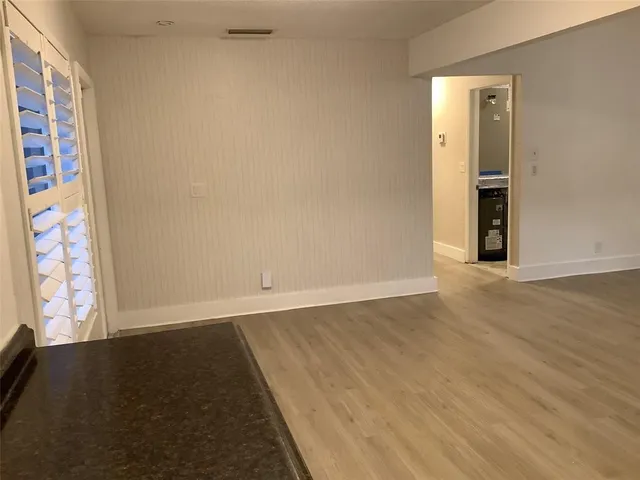 a view of a kitchen with stainless steel appliances wooden floor and a window
