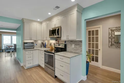 a kitchen with cabinets stainless steel appliances a sink and a window