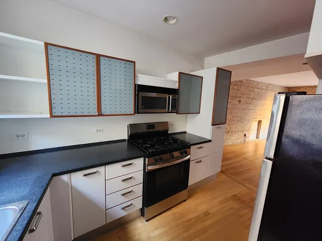 a kitchen with granite countertop white cabinets and black appliances