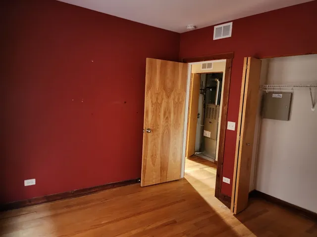an empty room with wooden floor and closet
