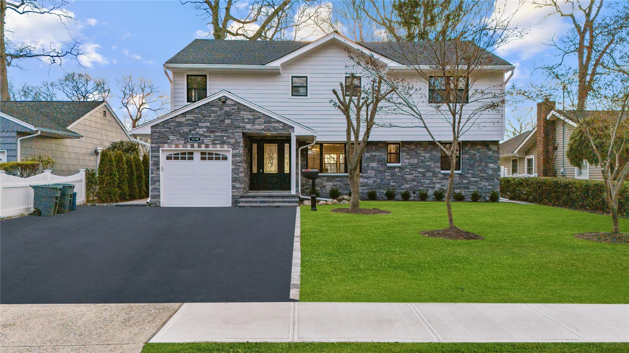 1574 Middle Neck Road Port Washington, NY 11050 - Photo 1 of 1 View of front of house with a front lawn and a garage