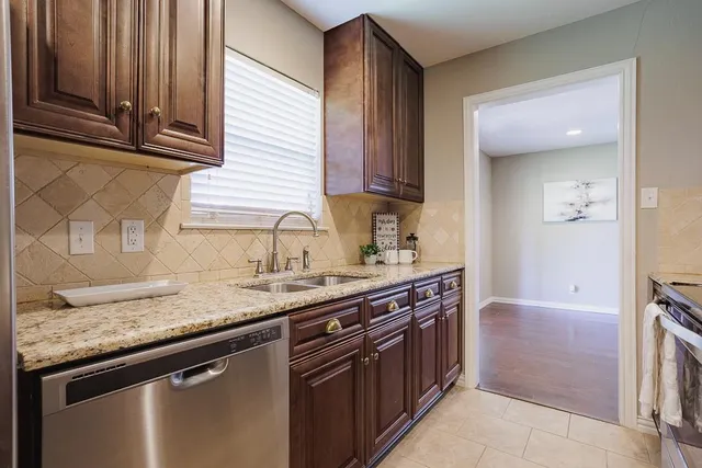 a kitchen with stainless steel appliances granite countertop a sink and a stove