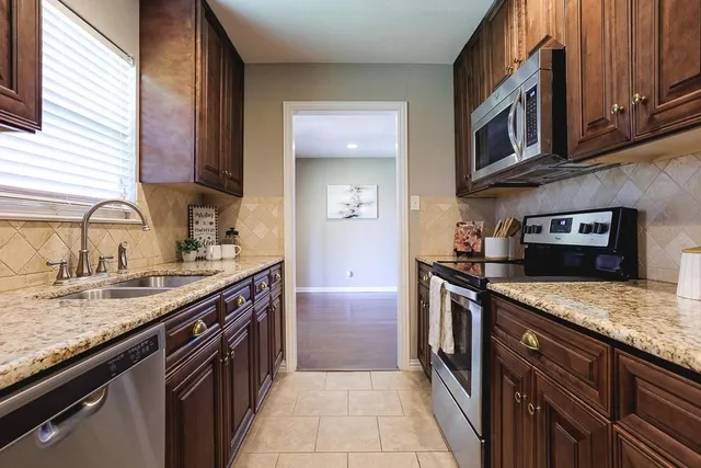 a kitchen with stainless steel appliances granite countertop a sink stove and cabinets