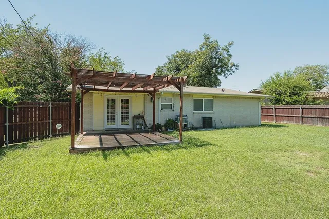 a view of a house with backyard and a tree