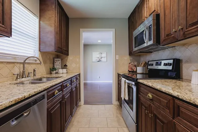 a kitchen with stainless steel appliances granite countertop a sink stove and cabinets
